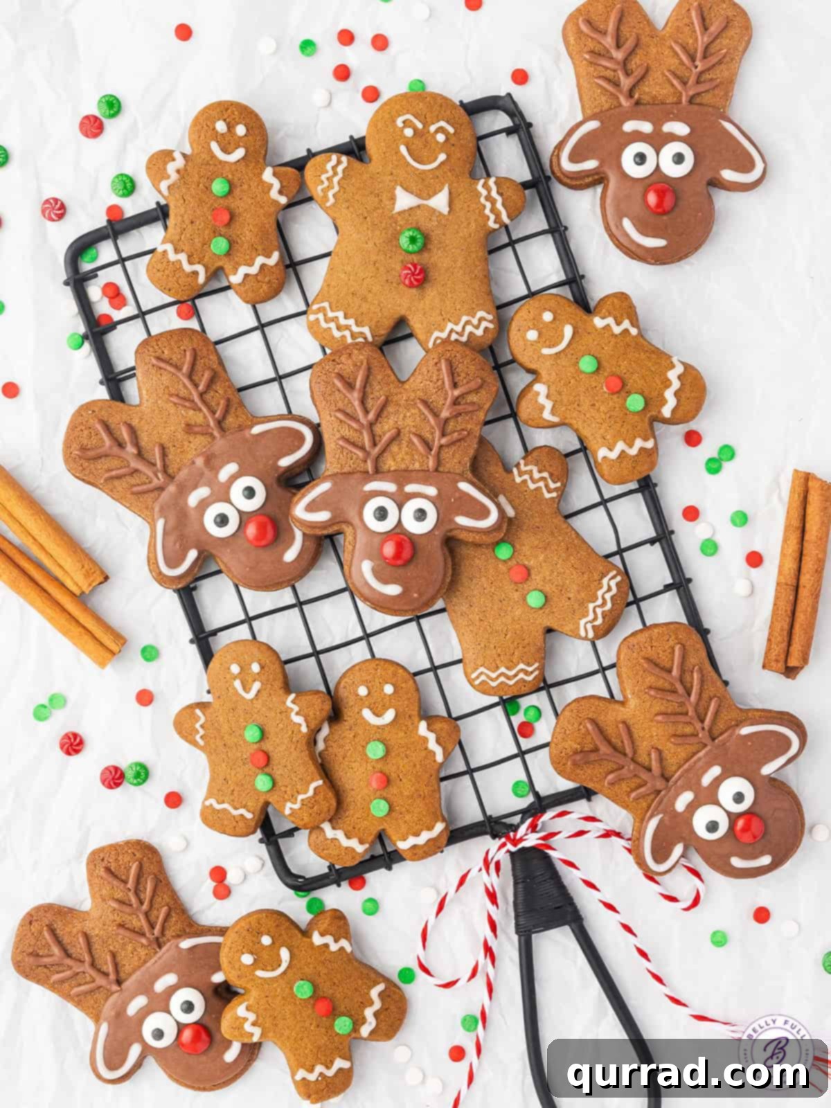 A cooling rack filled with baked gingerbread men and gingerbread reindeer cookies, some decorated with white icing.