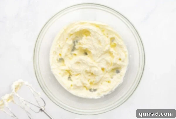 Creamed butter and sugar in a bowl, light and fluffy, ready for wet ingredients.