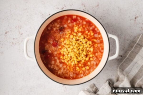 Southern Smokehouse Stew 8 Frozen corn added to Brunswick stew in a stew pot.