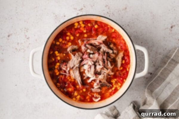 Southern Smokehouse Stew 9 Pulled porn added to Brunswick stew in a stew pot.