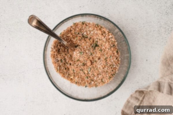 The blended prime rib rub in a bowl with a spoon, showing its consistent texture and color.