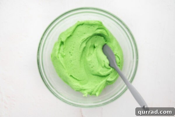 Stirring green food coloring into sugar cookie dough