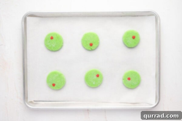 Overhead view of unbaked Grinch cookies on a baking sheet
