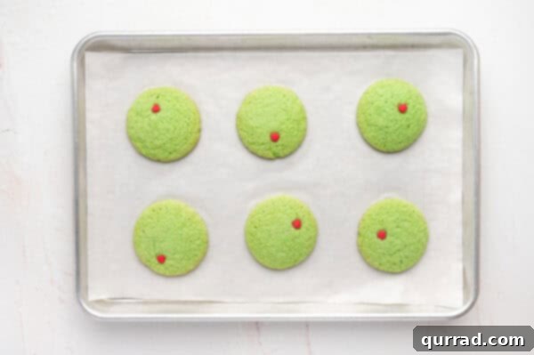 Overhead view of baked Grinch sugar cookies on a baking sheet