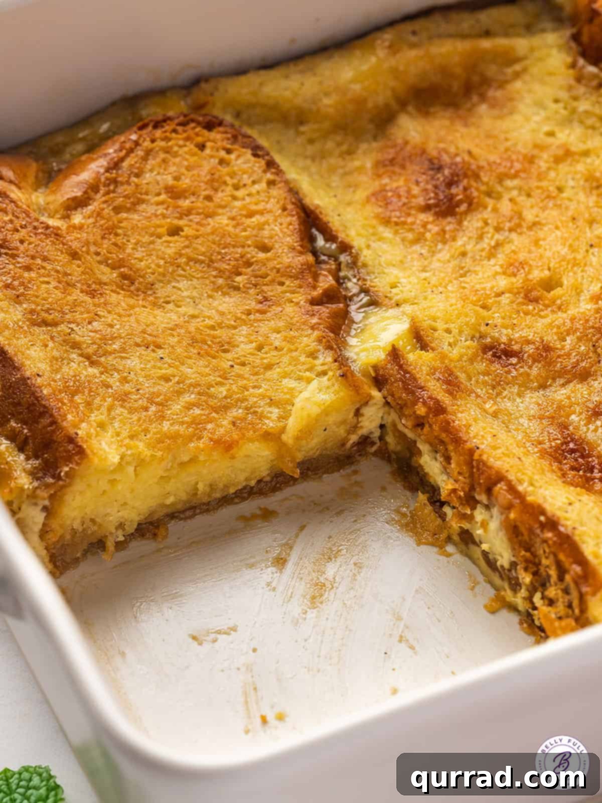 Eggnog overnight French toast casserole in a baking dish with a slice missing