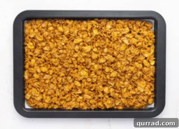 Crispy Cornflake Chocolate Bark 12 Overhead view of cornflake brittle baking on a sheet pan in the oven