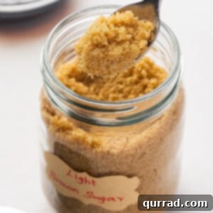 A spoon of brown sugar above a jar of brown sugar