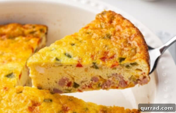 Serving a golden-brown slice of a Denver baked omelet, ready to eat