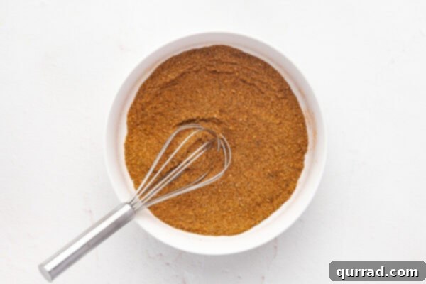 Coastal Classic Seasoning 4 A whisk blending various spices in a white bowl