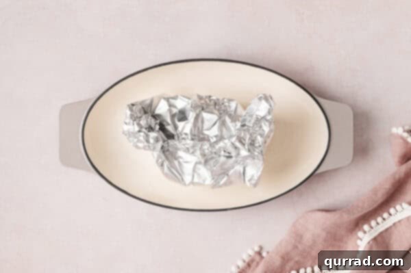 An onion wrapped in foil on a plate