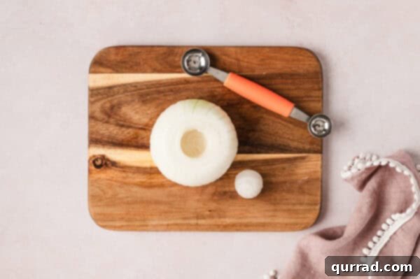 Overhead view of an onion and a corer on a cutting board