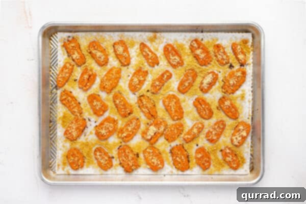 Baked parmesan smashed carrots on a baking sheet, fresh out of the oven