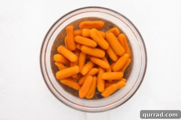 Baby carrots in a bowl of water ready for microwaving