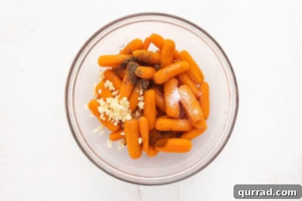 Seasonings being mixed in a bowl with baby carrots