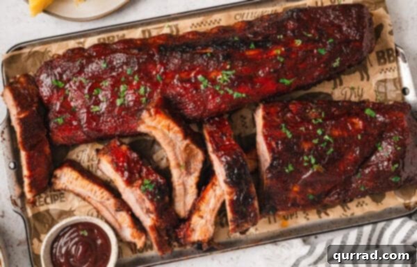 Fall-Off-The-Bone Baked Ribs 12 Baked baby back ribs being sliced on a cutting board