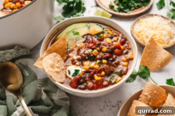 A bowl of 7 can soup, garnished with tortilla chips and avocado slices, ready to eat.