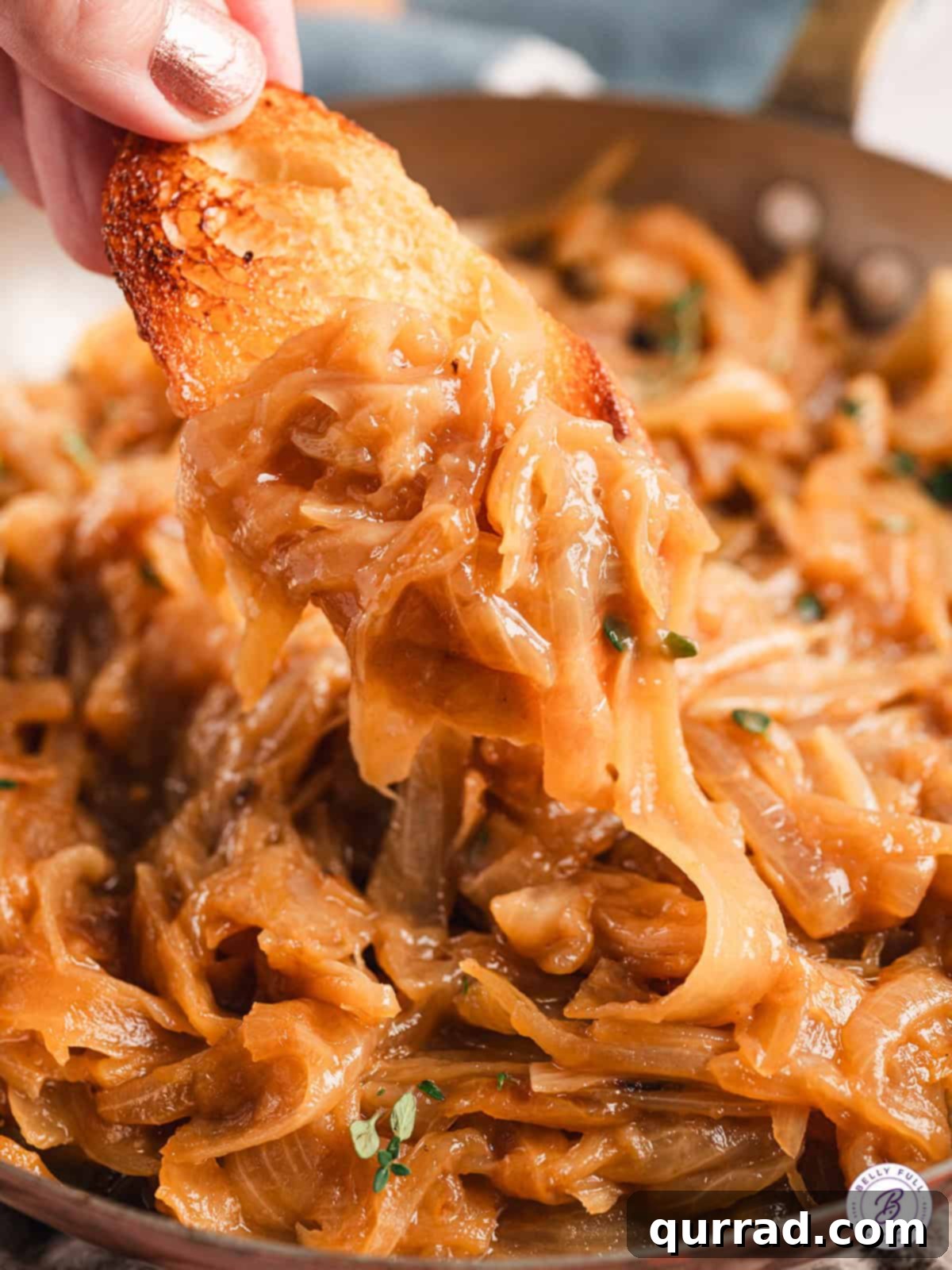 Enjoying Caramelized Onions: Perfect as a dip with chips or crostini, highlighting their versatile use. A hand gently dipping a crispy potato chip into a bowl of golden-brown, savory caramelized onions, ready for a delicious bite.
