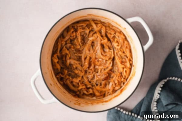 Onions fully caramelized in a pot, showcasing their glossy, rich brown texture, ready to be served.