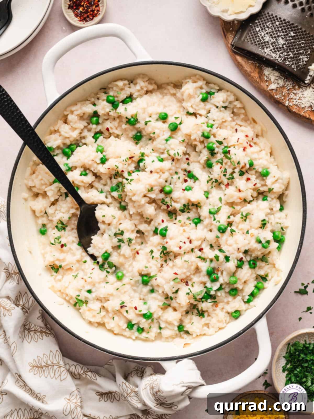 Effortless Baked Risotto: Creamy, Flavorful, and Easy to Make in the Oven A black spoon in a pot of golden, creamy baked risotto, garnished with fresh herbs.