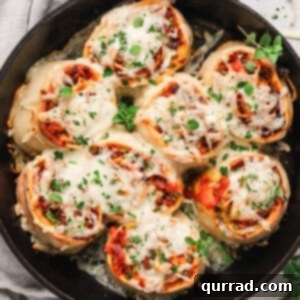 Overhead view of cheesy supreme pizza rolls in a cast iron skillet