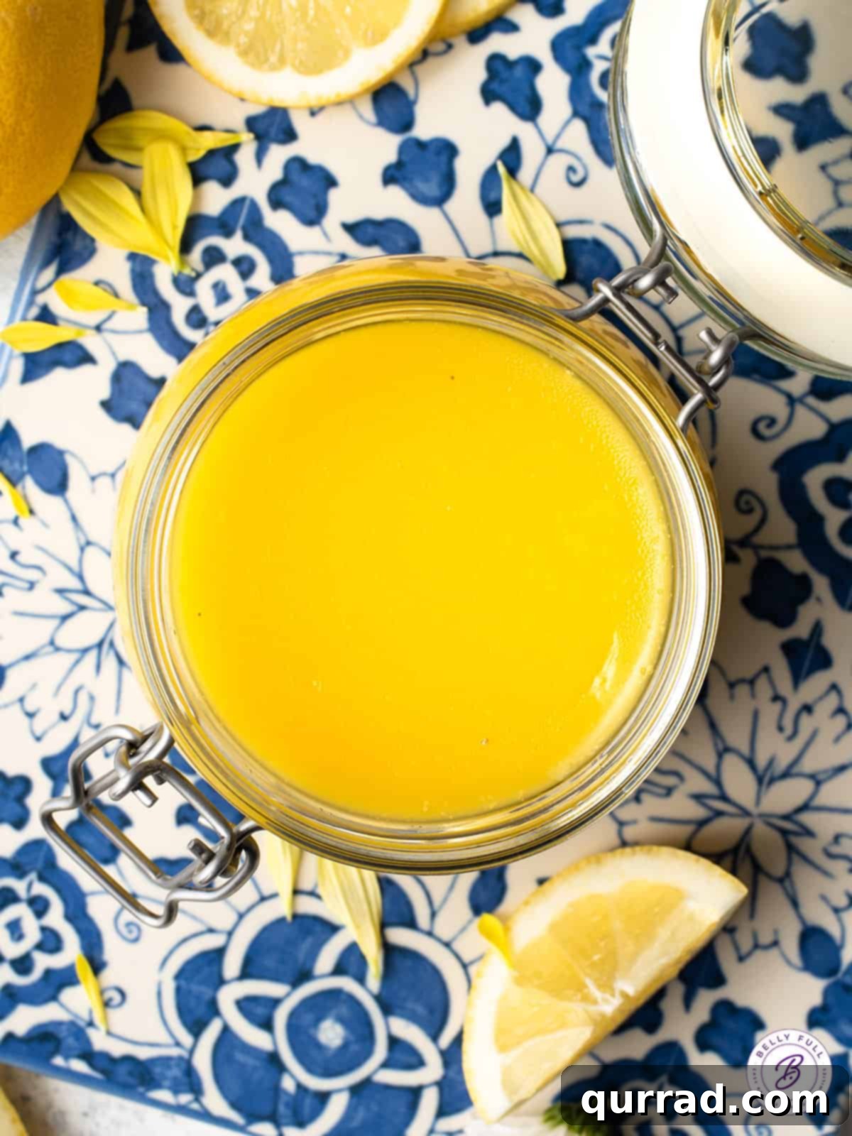 Golden Lemon Dream 5 An inviting overhead shot of bright yellow lemon curd in a glass container, showcasing its smooth, glossy surface.