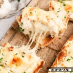 Creamy Chicken Alfredo French Bread Pizza 2 A top-down view of Chicken Alfredo French Bread Pizza with stringing cheese, fresh parsley, and golden crust.