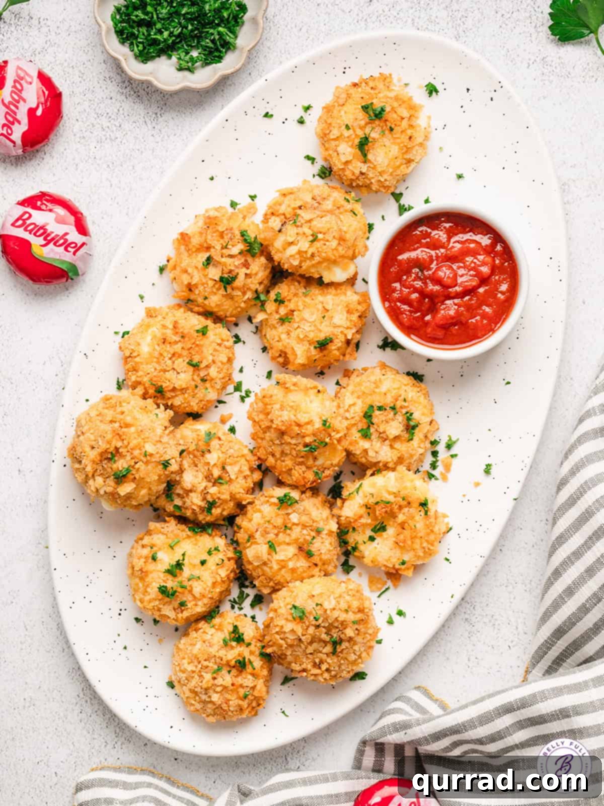 Serve up a crowd-pleasing platter of Air Fried Babybel Cheese – crispy on the outside, gooey on the inside, and simply delicious. A vibrant platter of golden-brown air fried babybel cheese, perfect for serving