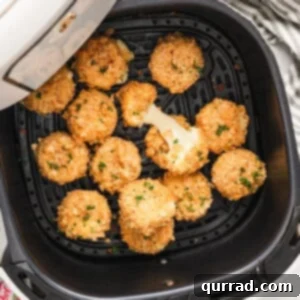 Air fried babybel cheese in the air fryer basket, golden and crispy