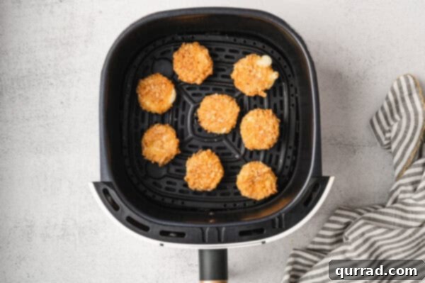 Irresistible Air-Fried Babybel Poppers 6 Breaded babybel cheese carefully placed in an air fryer basket