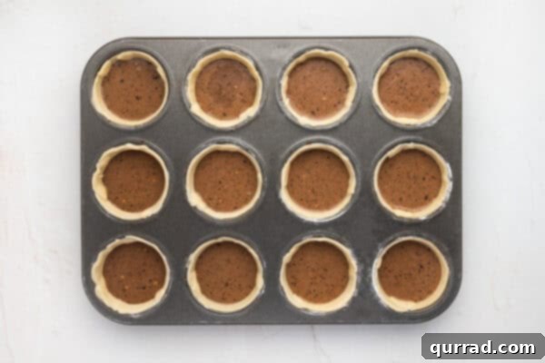 Unbaked mini chocolate pies in a muffin pan