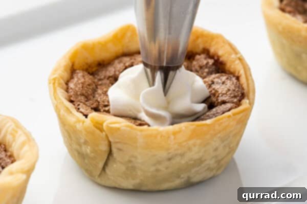 Piping whipped cream onto a mini chocolate pie