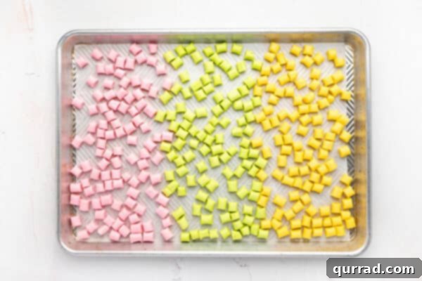 A baking sheet filled with colorful butter mints left out to dry at room temperature