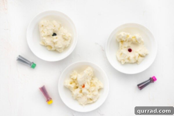 Mint dough divided into three bowls with drops of food coloring