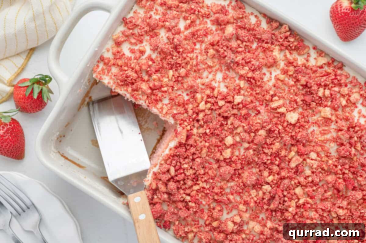 Strawberry Crunch Delight 9 A strawberry crunch cake in a cake pan with serving spatula