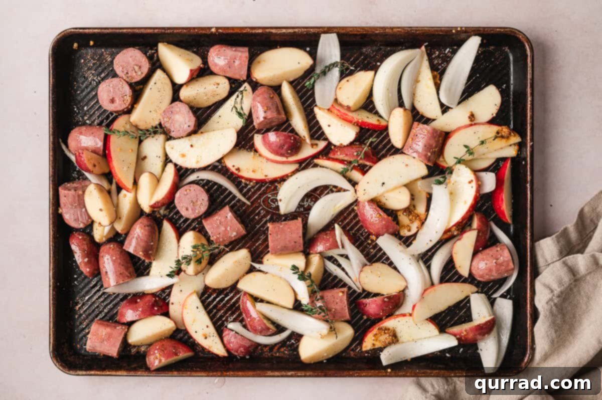 Harvest Sheet Pan Sausage and Apple Dinner 4 The sheet pan ingredients are thoroughly tossed with olive oil, Dijon mustard, salt, and pepper, then spread in an even layer with fresh thyme sprigs on top.
