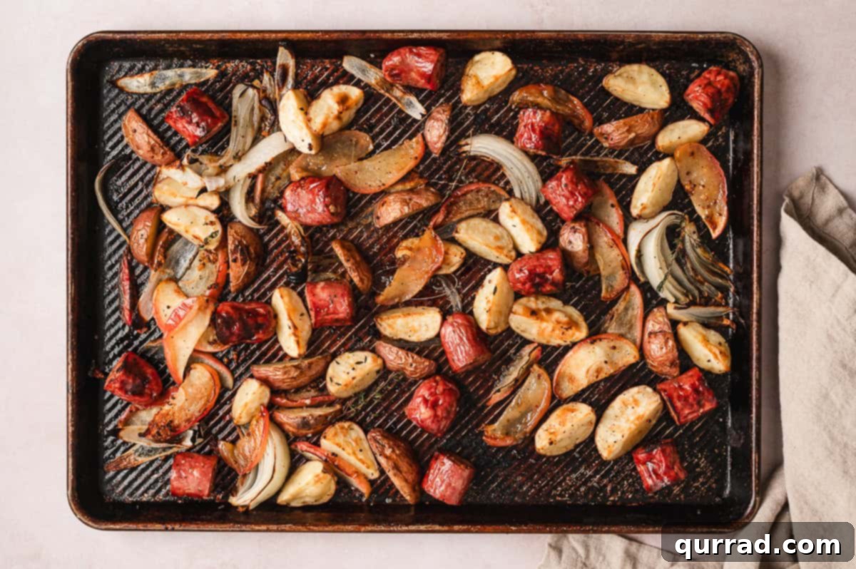 Harvest Sheet Pan Sausage and Apple Dinner 5 The sheet pan dinner actively roasting in the oven, with sausage browning, potatoes softening, and apples caramelizing to perfection.