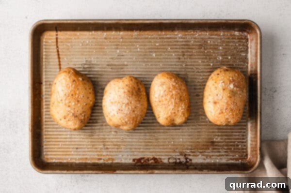 Loaded Baked Potato Delights 6 Four jacket potatoes on a baking sheet.