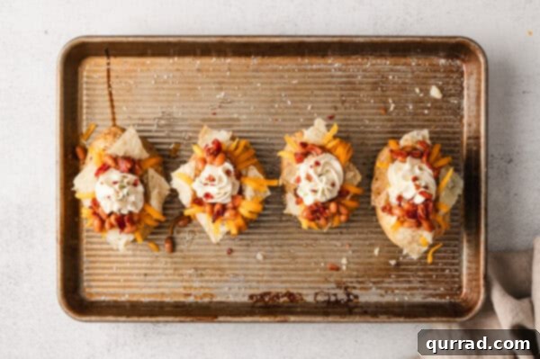 Loaded Baked Potato Delights 9 Overhead view of stuffed jacket potatoes, topped with beans, cheese, and whipped cream cheese.