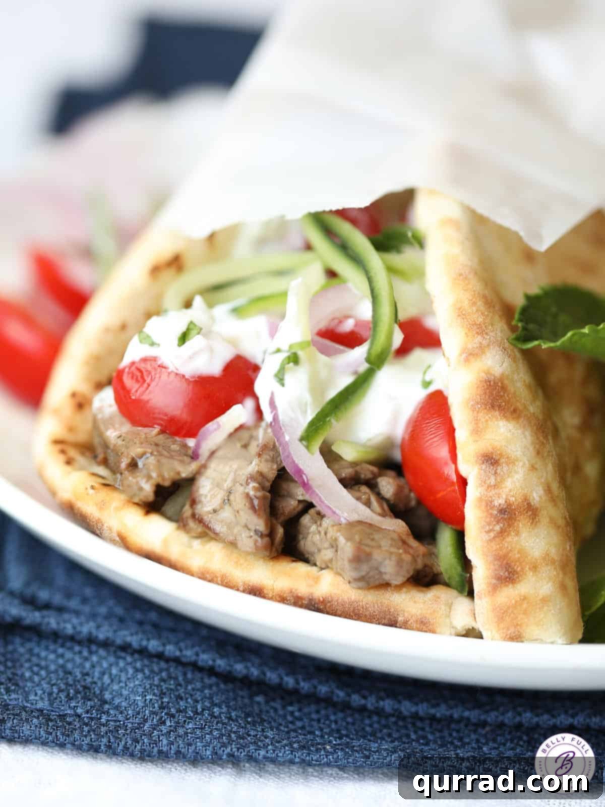 Delicious Beef Gyros wrapped in parchment paper, ready to be served, showcasing tender beef, fresh vegetables, and creamy tzatziki sauce.