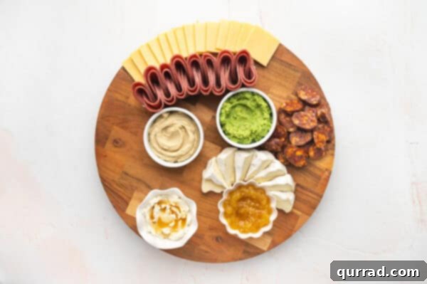 Cheeses, cured meats (salami, chorizo), and dips assembled on a charcuterie board