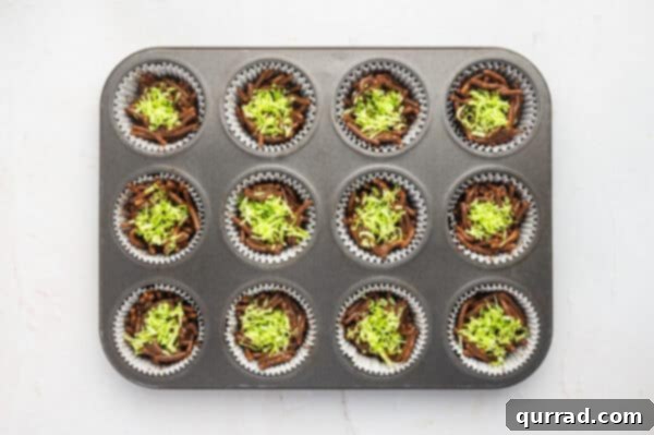 Green shredded coconut on top of chocolate covered chow mein noodles in a muffin pan