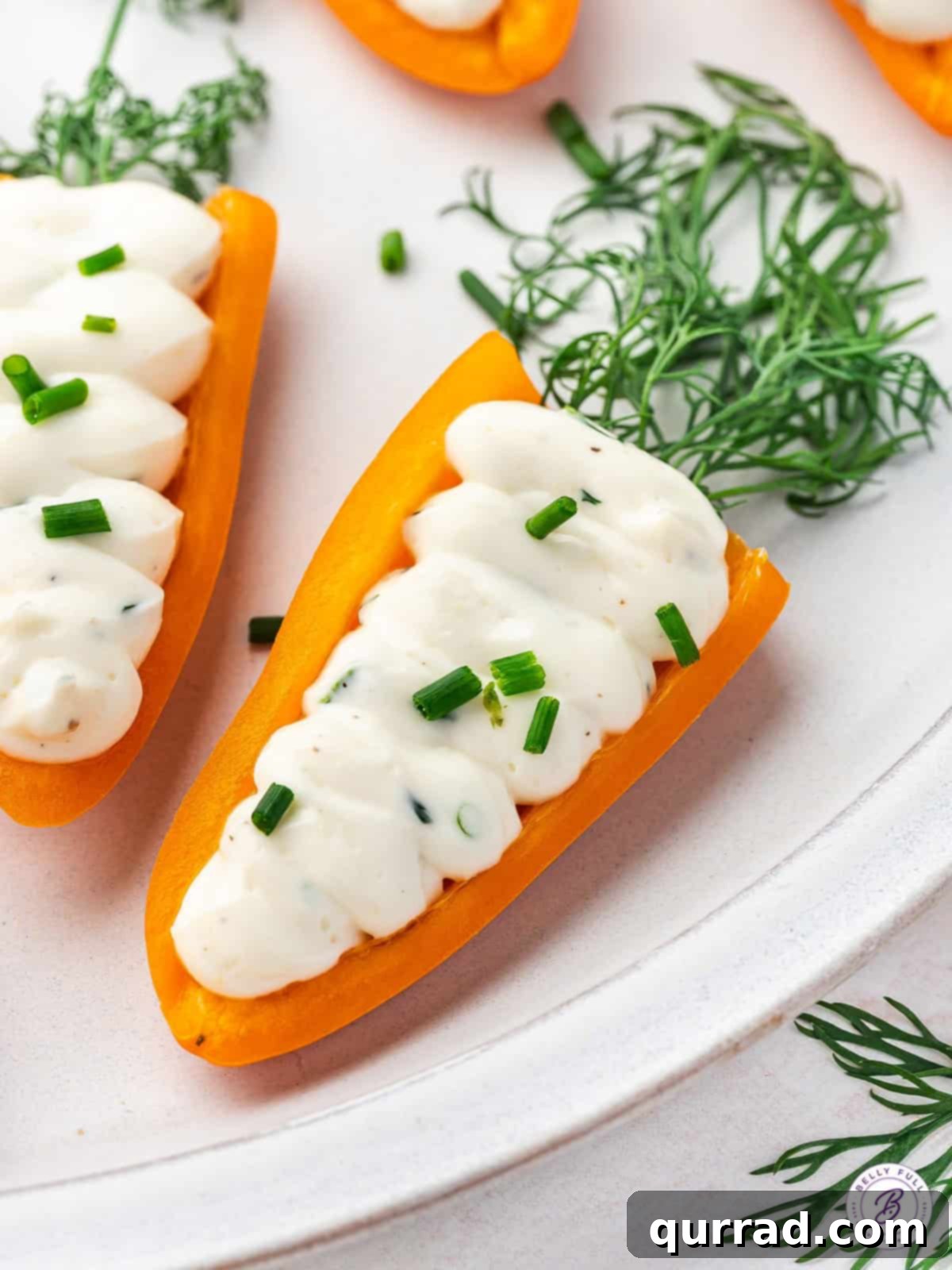 Carrot-Stuffed Bell Pepper Bites 7 Stuffed mini bell pepper carrots on a white plate