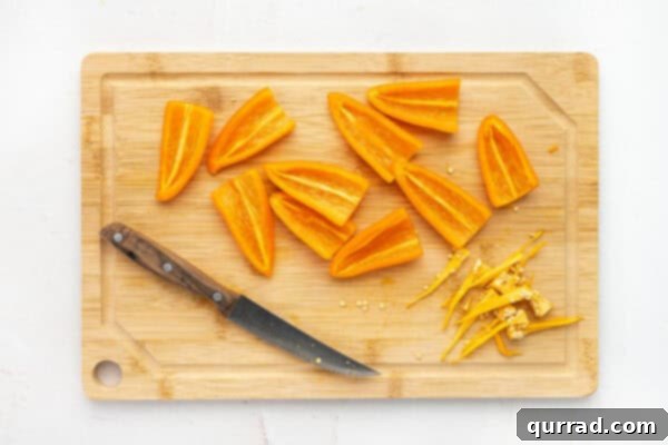 Carrot-Stuffed Bell Pepper Bites 3 Orange mini bell peppers cut in half on a cutting board