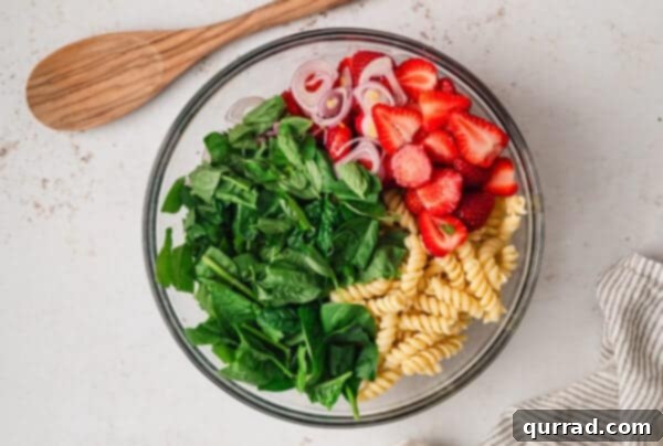 Rotini, spinach, and strawberries in a bowl