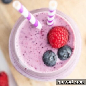 overhead blueberry smoothie with 2 blueberries and 1 raspberry on top