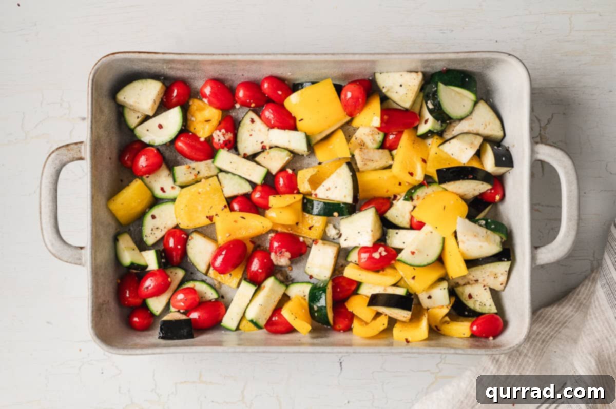 Velvety Ratatouille Pasta 4 Bell pepper, zucchini, tomatoes, and eggplant on a baking sheet, prepped for roasting.