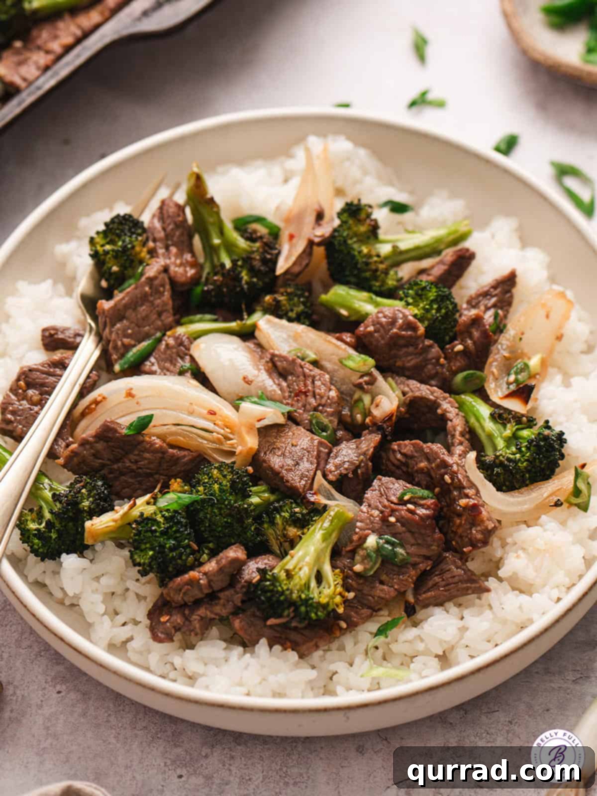 This Sheet Pan Beef & Broccoli is a quick, easy twist on the popular Chinese takeout. Ready in under 30 minutes using just one pan! Sheet pan beef & broccoli served beautifully over white rice in a bowl.