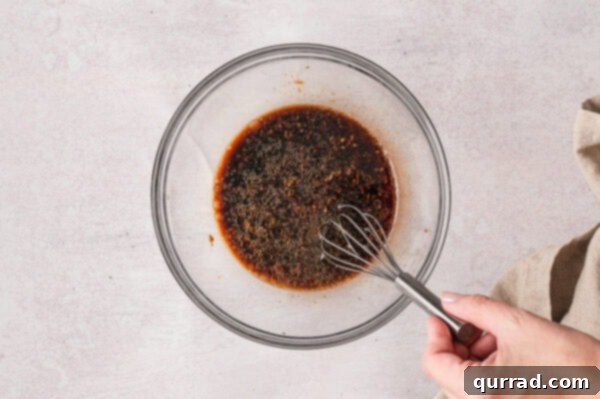 Effortless Sheet Pan Beef and Broccoli 2 Whisking soy sauce marinade in a bowl, showing the rich texture.