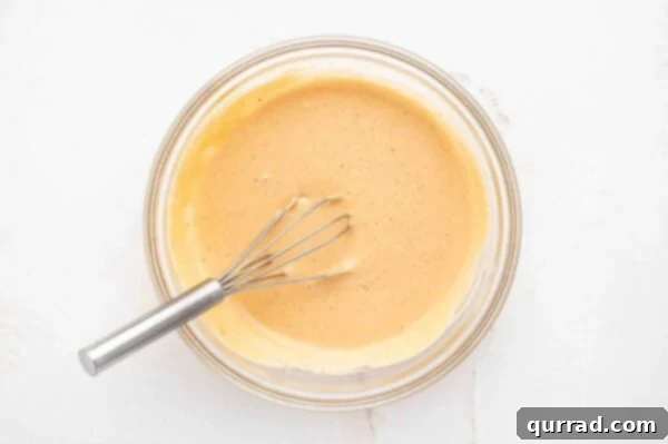 The Encore Sauce 4 A whisk blending all the comeback sauce ingredients in a bowl.