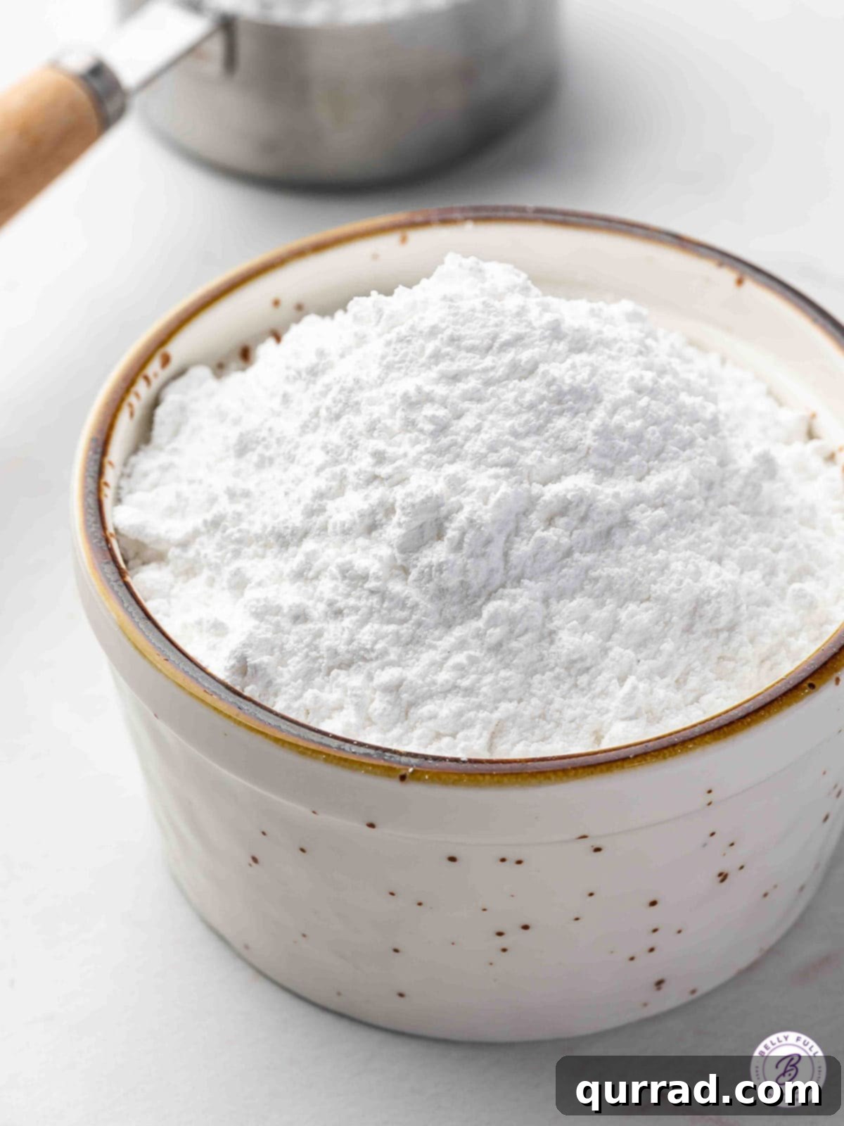 A small bowl of fluffy homemade powdered sugar, ready for use.